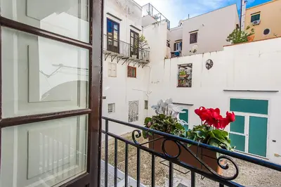 a balcony with a window with red flowers on it at Torremuzza Homes by Wonderful Italy in Palermo