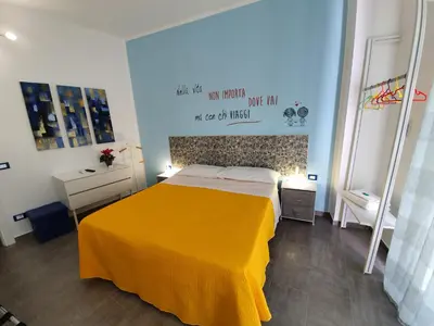 a bedroom with a bed with a yellow blanket on it at Arco del Sole 2 in Palermo