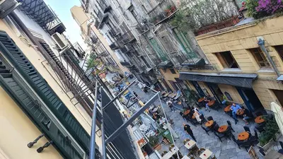 an overhead view of a group of people in a courtyard between buildings at Arco del Sole 2 in Palermo
