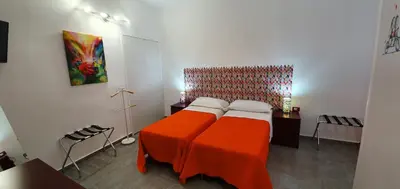 a bedroom with a bed with an orange blanket at Arco del Sole 2 in Palermo