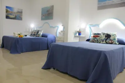 a bedroom with two beds with blue sheets and pillows at EXCLUSIVE HOME in Castellammare del Golfo