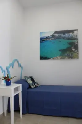 a blue couch in a room with a view of the ocean at EXCLUSIVE HOME in Castellammare del Golfo