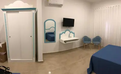a room with a bed and two chairs and a sink at EXCLUSIVE HOME in Castellammare del Golfo