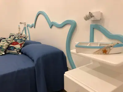 a bedroom with a blue bed and a sink at EXCLUSIVE HOME in Castellammare del Golfo