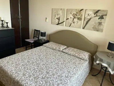 a bedroom with a bed and some pictures on the wall at Villa Ibiscus in Mandra Capreria