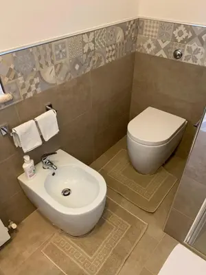 a bathroom with a toilet and a sink at Villa Ibiscus in Mandra Capreria