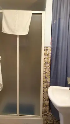 a bathroom with a shower with a sink and a toilet at La casetta del vicoletto in Palermo
