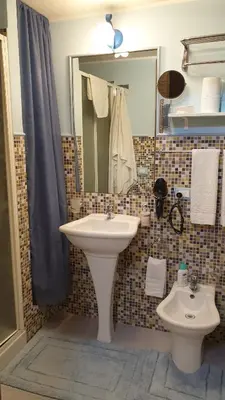 a bathroom with a sink and a mirror and a toilet at La casetta del vicoletto in Palermo