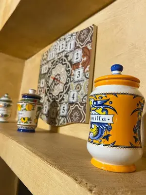 three small vases sitting on a shelf with a picture at La casetta del vicoletto in Palermo