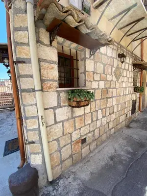 a brick building with a window and a potted plant at La casetta del vicoletto in Palermo