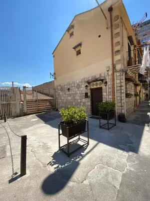 a building with two potted plants in front of it at La casetta del vicoletto in Palermo