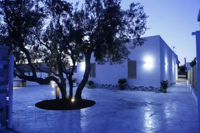 a tree in a courtyard next to a building at Villa con piscina Alcamo Marina in Alcamo