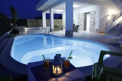 a large swimming pool in a backyard at night at Villa con piscina Alcamo Marina in Alcamo