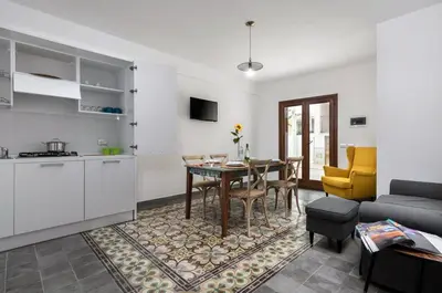 a kitchen and living room with a table and a couch at Finisterre in San Vito lo Capo