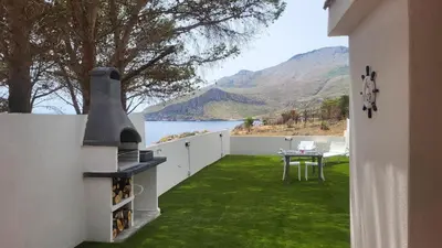 a balcony with a table and a view of the water at Villetta SanVito - Sunrise & Sunset in San Vito lo Capo