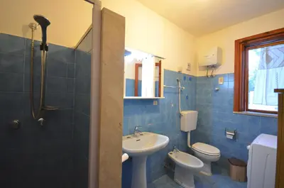 a blue bathroom with two toilets and a sink at Villetta SanVito - Sunrise & Sunset in San Vito lo Capo