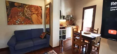 a living room with a blue couch and a table at Palermo Holiday Studio in Palermo