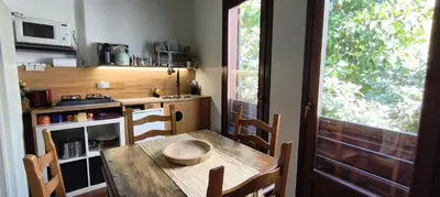 a small kitchen with a wooden table and a window at Palermo Holiday Studio in Palermo