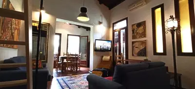 a living room with blue couches and a dining room at Palermo Holiday Studio in Palermo