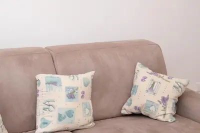 a brown couch with two pillows on it at Appartamento Conturrana Sul Mare in San Vito lo Capo