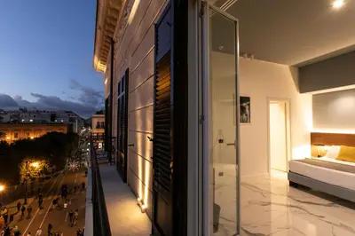 a building with a view of a city at night at Palazzo Sovrana Serviced Luxury Apartments in Palermo