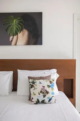 a person holding a plant above a bed at Palazzo Sovrana Serviced Luxury Apartments in Palermo