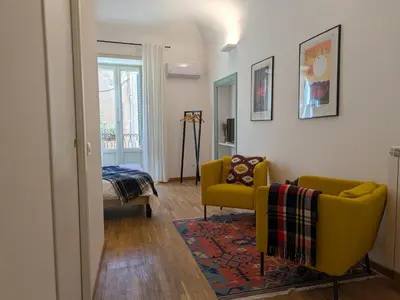 a living room with a yellow chair and a couch at B&B del Parlamento in Palermo