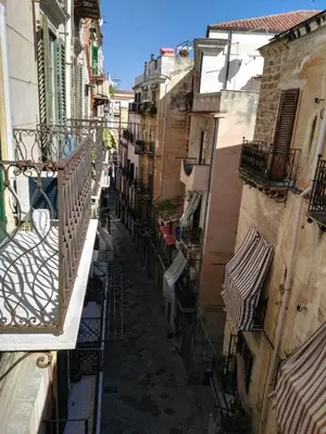 an alley between two buildings with balconies at B&B del Parlamento in Palermo