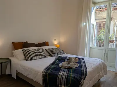 a bedroom with a bed with a plaid blanket at B&B del Parlamento in Palermo