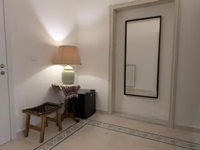 a lamp and a chair in a room with a mirror at B&B del Parlamento in Palermo