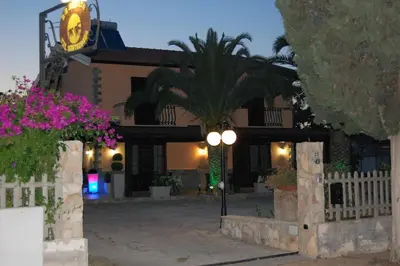 a house with a palm tree in front of it at Sunrise in Lascari