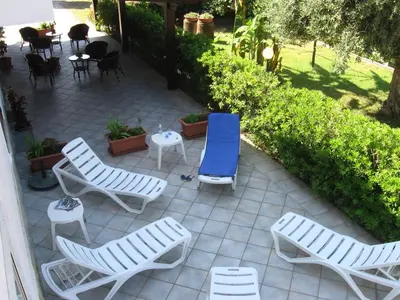 a patio with chaise lounge chairs and a table at Sunrise in Lascari