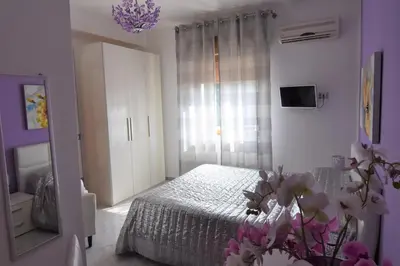 a bedroom with a bed and a mirror and flowers at Bed and Breakfast Il Girasole in Mondello