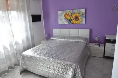 a bedroom with a bed and a purple wall at Bed and Breakfast Il Girasole in Mondello