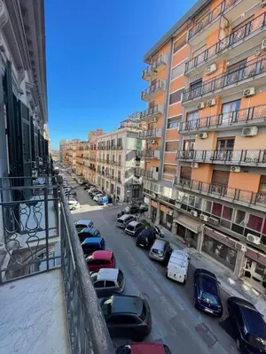 a city street with cars parked in front of buildings at Palazzo Gallo in Palermo