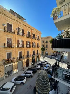 a city street with cars parked in front of buildings at Palazzo Gallo in Palermo