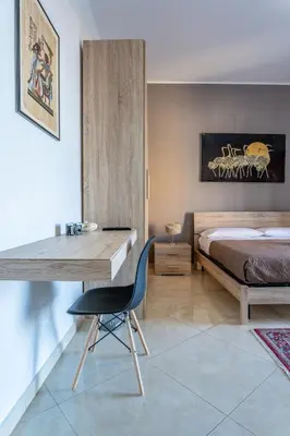 a bedroom with a bed and a desk with a chair at B&B Una Terrazza sul Golfo di Sferracavallo in Sferracavallo