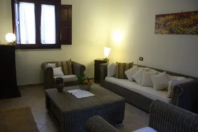 a living room with a couch and chairs and a table at Villa Giardino Paradiso Cefalù con 13 posti letto e piscina riscaldata in Cefalù