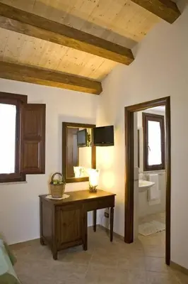 a bathroom with a desk and a sink and a mirror at Villa Giardino Paradiso Cefalù con 13 posti letto e piscina riscaldata in Cefalù