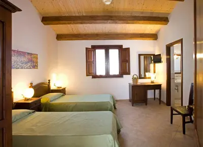 a hotel room with two beds and a mirror at Villa Giardino Paradiso Cefalù con 13 posti letto e piscina riscaldata in Cefalù