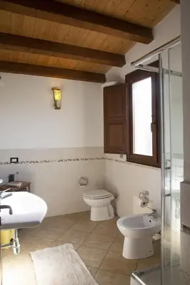 a bathroom with a toilet and a sink at Villa Giardino Paradiso Cefalù con 13 posti letto e piscina riscaldata in Cefalù