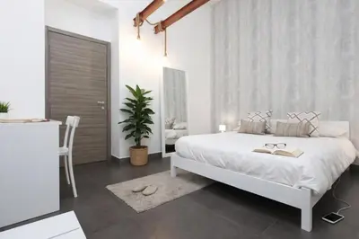 a bedroom with a large white bed with pillows at Palermo Inn Suite in Palermo