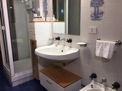 a white bathroom with a sink and a shower at Armida House - Mondello in Mondello