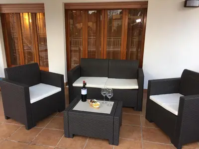 a patio with two chairs and a table with a bottle of wine at Armida House - Mondello in Mondello