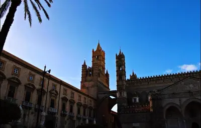 a building with a clock tower in the background at Dietro la Cattedrale in Palermo