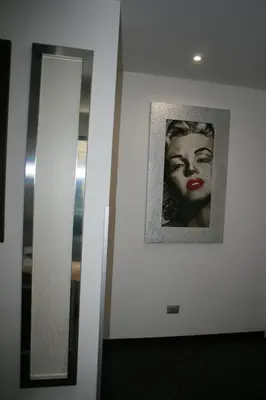 a mirror and a picture of a woman on a wall at Mille e Una Notte in Nuova Gibellina