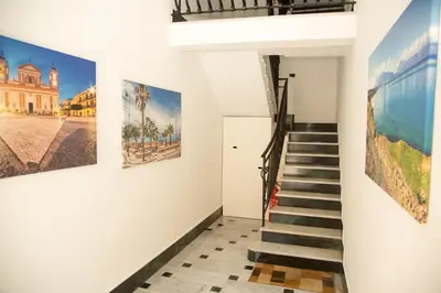 a staircase in a house with paintings on the walls at Sicilia Case Vacanze in Balestrate