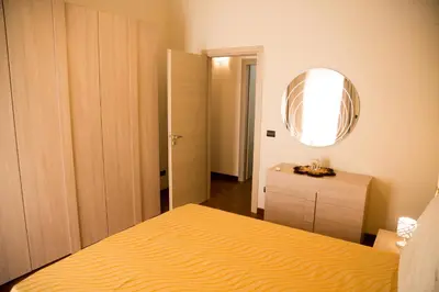 a bedroom with a yellow bed and a mirror at Sicilia Case Vacanze in Balestrate