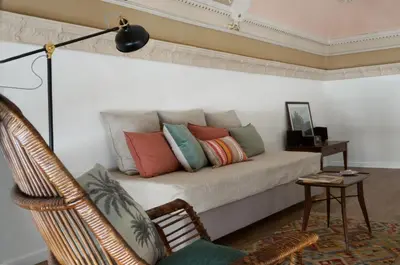a couch with colorful pillows on it in a room at T-home / Stylish apartment Palermo center in Palermo