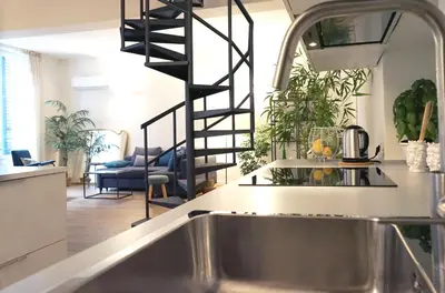 a kitchen with a kitchen sink and a spiral staircase at T-home / Stylish apartment Palermo center in Palermo